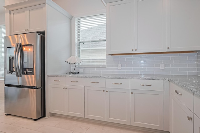 21307 Metallic Blue Dr, Cypress, TX 77433 - kitchen featuring stainless steel refrigerator with ice dispenser, backsplash, light stone countertops, and light tile patterned flooring