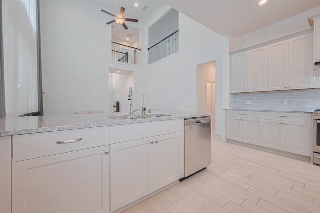 21307 Metallic Blue Dr, Cypress, TX 77433 - kitchen with stainless steel appliances, a sink, a high ceiling, tasteful backsplash, and a ceiling fan