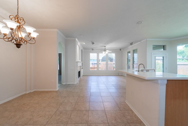 5226 Englewood Point Ct, Katy, TX 77494 - unfurnished living room featuring crown molding, plenty of natural light, a ceiling fan, a chandelier, and light tile patterned flooring