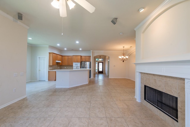 5226 Englewood Point Ct, Katy, TX 77494 - kitchen featuring stainless steel fridge, a ceiling fan, a fireplace, crown molding, and a chandelier