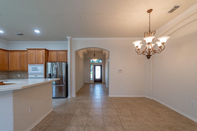 5226 Englewood Point Ct, Katy, TX 77494 - kitchen featuring stainless steel fridge with ice dispenser, arched walkways, white microwave, light countertops, and pendant lighting