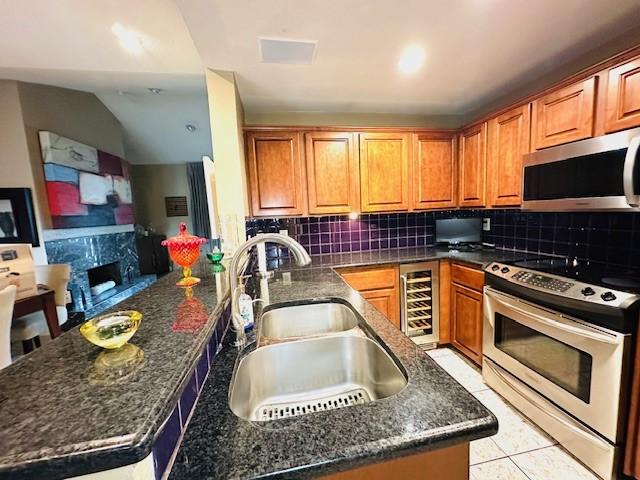 12660 Hillcrest Rd Unit 2203, Dallas, TX 75230 - kitchen featuring stainless steel appliances, a sink, tasteful backsplash, and wine cooler