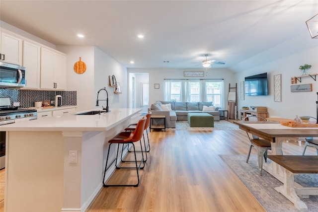 16935 Lagos Ln, Crosby, TX 77532 - kitchen featuring a sink, stainless steel appliances, ceiling fan, light wood-style floors, and recessed lighting