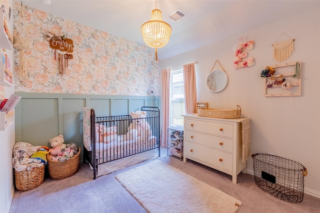 16935 Lagos Ln, Crosby, TX 77532 - carpeted bedroom with a chandelier, a crib, wallpapered walls, and wainscoting