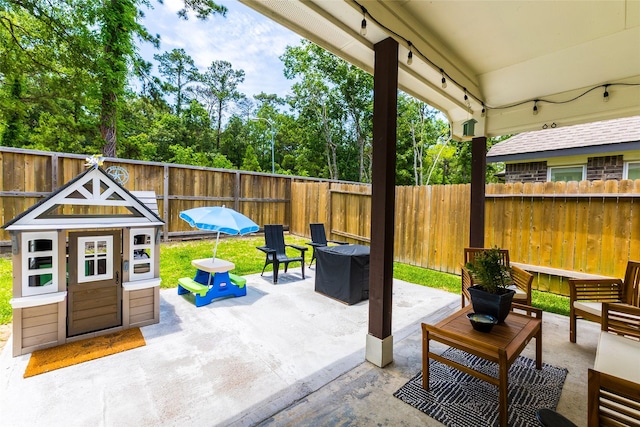 16935 Lagos Ln, Crosby, TX 77532 - fenced backyard featuring a patio, an outdoor hangout area, and view of scattered trees