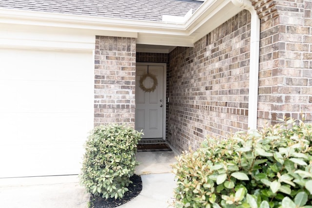 16935 Lagos Ln, Crosby, TX 77532 - property entrance featuring roof with shingles, brick siding, and a garage