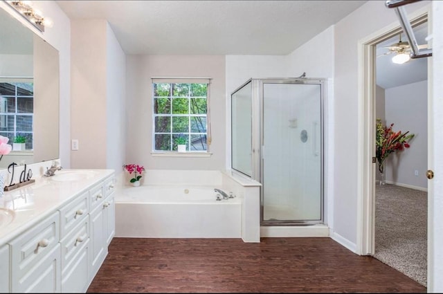 134 Willowwood Cir, The Woodlands, TX 77381 - full bathroom with double vanity, a shower stall, a garden tub, and wood finished floors