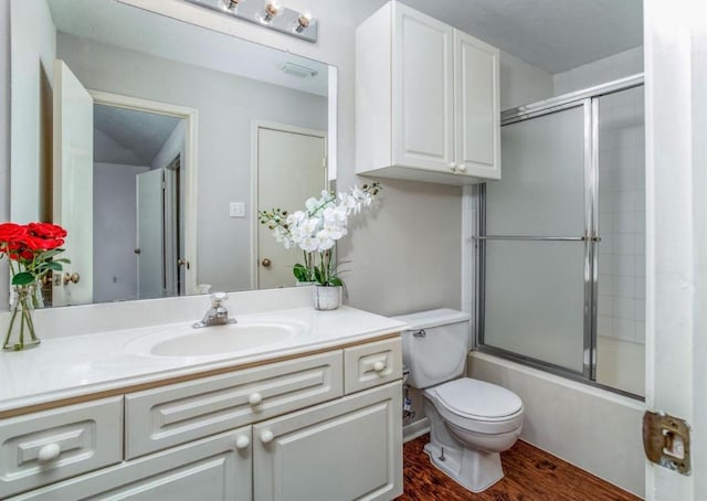 134 Willowwood Cir, The Woodlands, TX 77381 - bathroom with vanity, toilet, combined bath / shower with glass door, and wood finished floors