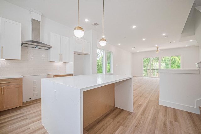 6023 Maybell, Houston, TX 77091 - kitchen featuring wall chimney exhaust hood, light wood-type flooring, backsplash, hanging light fixtures, and recessed lighting