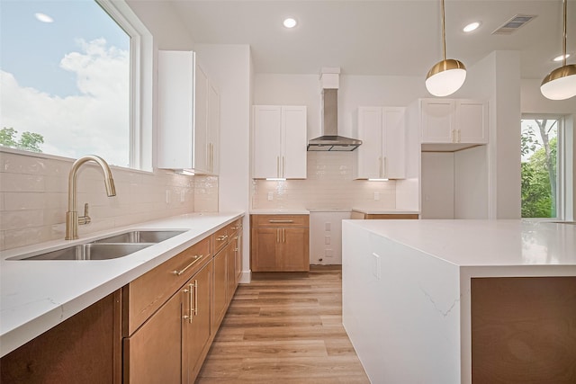6023 Maybell, Houston, TX 77091 - kitchen featuring a sink, wall chimney range hood, light wood-style floors, decorative backsplash, and recessed lighting
