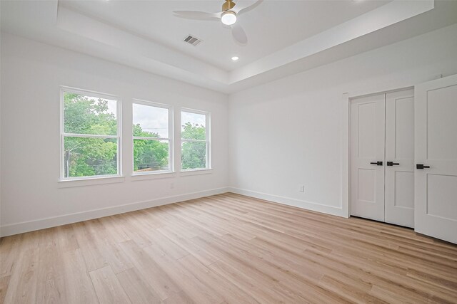 6023 Maybell, Houston, TX 77091 - unfurnished bedroom with a raised ceiling, multiple windows, light wood-style floors, baseboards, and recessed lighting