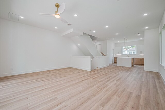 6023 Maybell, Houston, TX 77091 - unfurnished living room featuring light wood-type flooring, a sink, baseboards, a ceiling fan, and recessed lighting