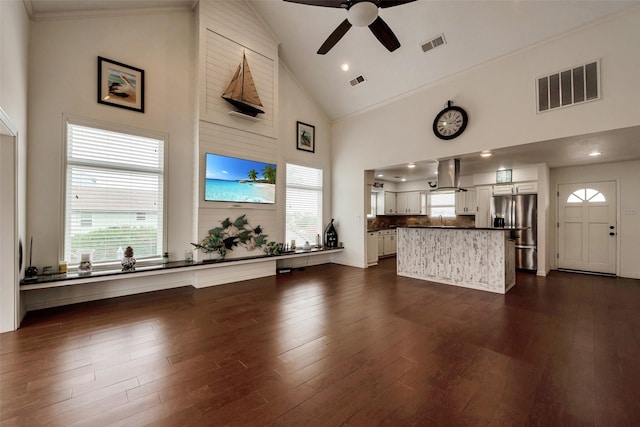 1302 Tiki Dr, Tiki Island, TX 77554 - living area with high vaulted ceiling, ceiling fan, dark wood-type flooring, and plenty of natural light