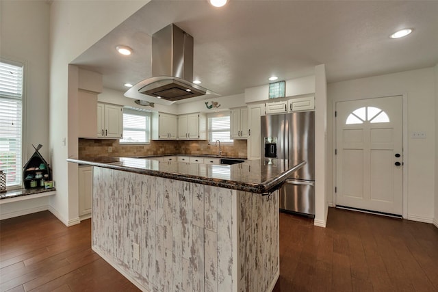 1302 Tiki Dr, Tiki Island, TX 77554 - kitchen with stainless steel fridge with ice dispenser, a sink, island range hood, dark wood-style floors, and dark stone countertops
