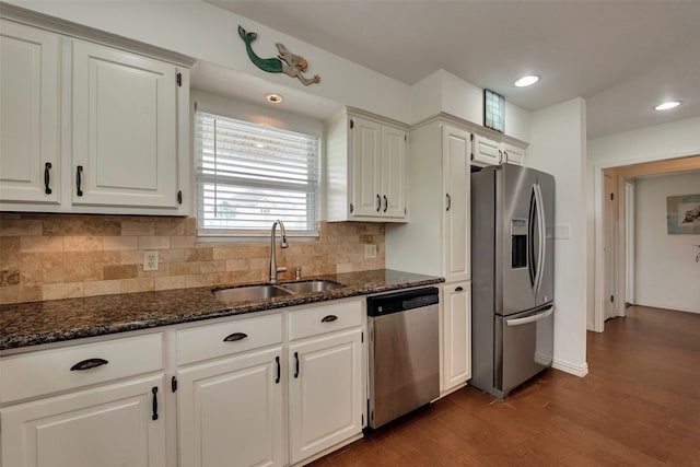 1302 Tiki Dr, Tiki Island, TX 77554 - kitchen with stainless steel appliances, a sink, backsplash, dark stone counters, and dark wood finished floors
