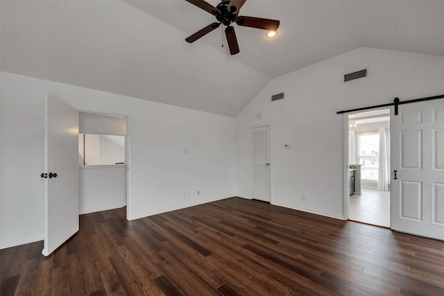 1302 Tiki Dr, Tiki Island, TX 77554 - spare room featuring a ceiling fan, vaulted ceiling, dark wood-style flooring, and a barn door