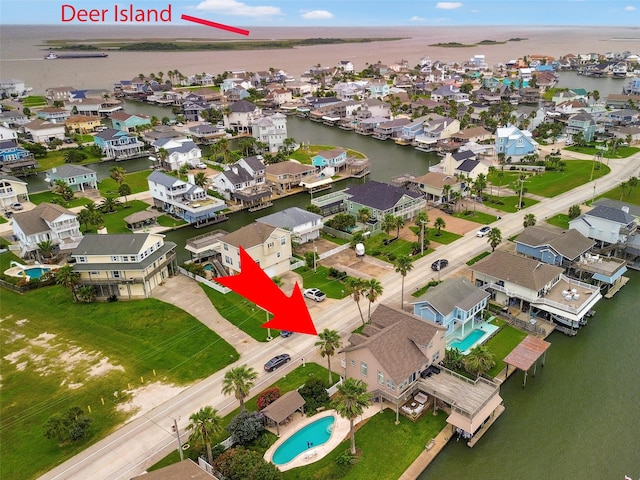 1302 Tiki Dr, Tiki Island, TX 77554 - aerial perspective of suburban area with a large body of water and a pool area
