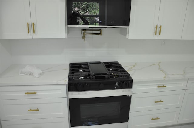 2522 Cassius Ct, New Caney, TX 77357 - kitchen featuring gas range oven, white cabinets, tasteful backsplash, and light stone counters