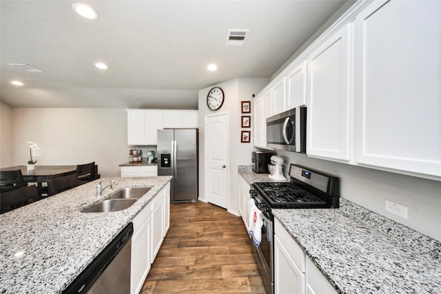 14133 Sharktooth Hill Ln, Conroe, TX 77384 - kitchen featuring appliances with stainless steel finishes, a sink, dark wood finished floors, white cabinets, and recessed lighting