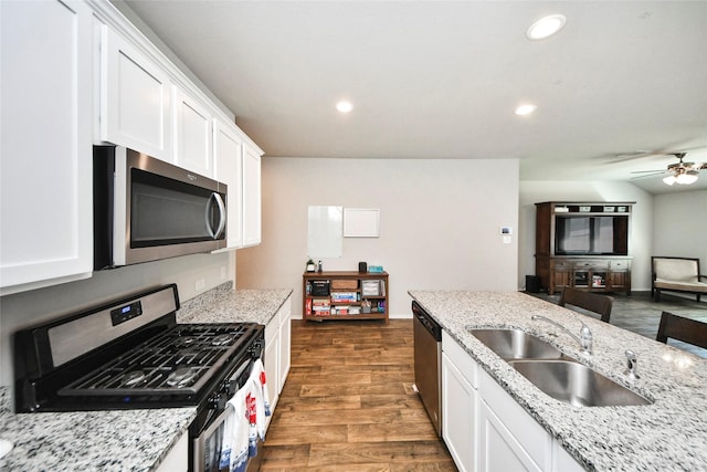 14133 Sharktooth Hill Ln, Conroe, TX 77384 - kitchen featuring stainless steel appliances, a sink, white cabinets, dark wood-style flooring, and recessed lighting
