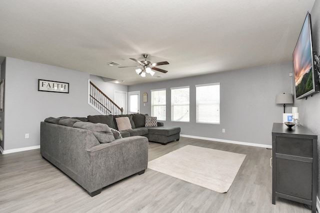 15543 Sheldon Ridge Way, Houston, TX 77044 - living room with ceiling fan, light wood-style flooring, baseboards, and stairway