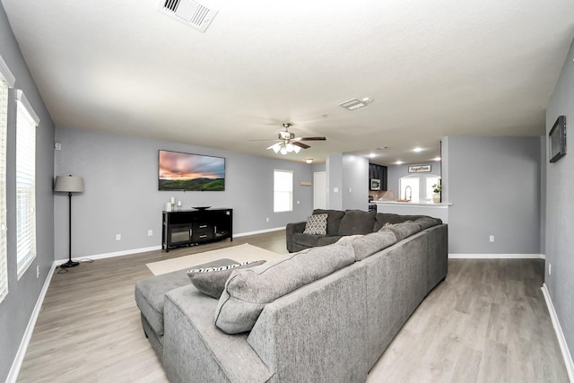 15543 Sheldon Ridge Way, Houston, TX 77044 - living room with baseboards, light wood-type flooring, and a ceiling fan