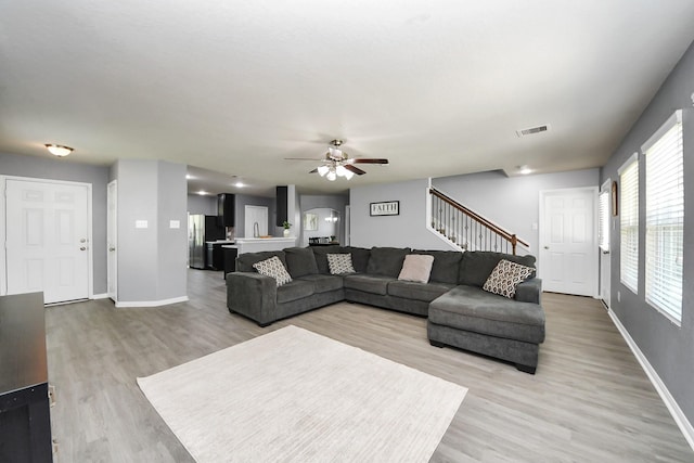 15543 Sheldon Ridge Way, Houston, TX 77044 - living room with stairs, light wood-style floors, ceiling fan, and baseboards