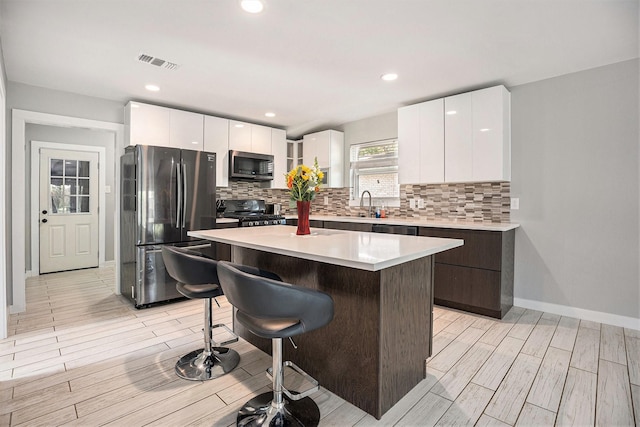 330 Pebblebrook Dr, El Lago, TX 77586 - kitchen featuring appliances with stainless steel finishes, modern cabinets, a kitchen bar, a sink, and recessed lighting
