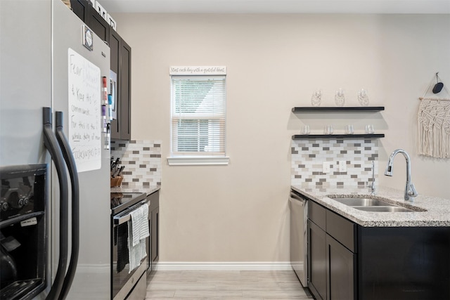 237 Ridgeside Ct, Montgomery, TX 77316 - kitchen with stainless steel appliances, a sink, decorative backsplash, open shelves, and light stone countertops