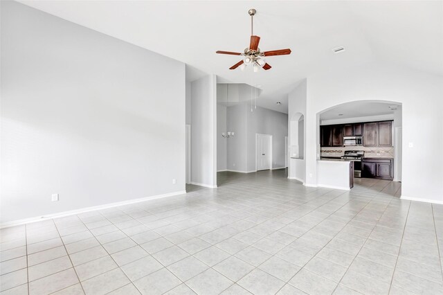 30510 Legend Oaks Ct, Magnolia, TX 77355 - unfurnished living room featuring light tile patterned floors, ceiling fan, arched walkways, baseboards, and high vaulted ceiling