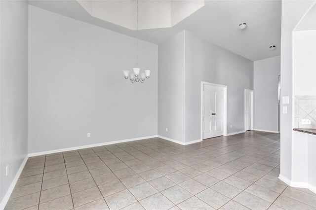 30510 Legend Oaks Ct, Magnolia, TX 77355 - spare room featuring light tile patterned flooring, a chandelier, baseboards, and a high ceiling