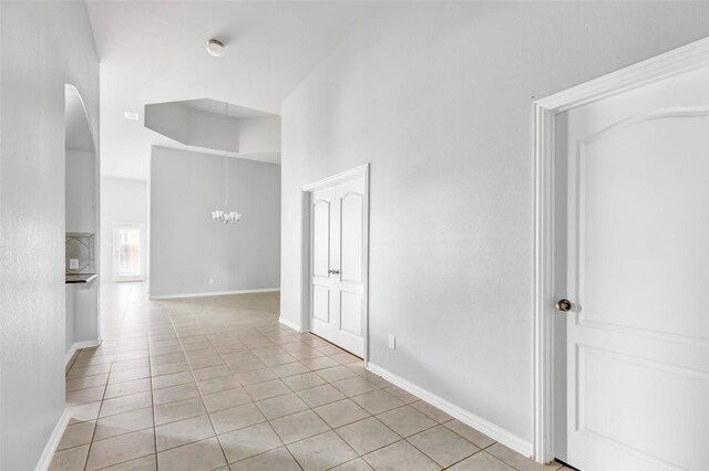 30510 Legend Oaks Ct, Magnolia, TX 77355 - unfurnished room featuring light tile patterned floors, a chandelier, arched walkways, baseboards, and a high ceiling