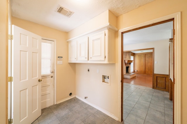 6914 Coral Ridge Rd, Houston, TX 77069 - laundry room featuring hookup for an electric dryer, cabinet space, washer hookup, a fireplace, and a wainscoted wall