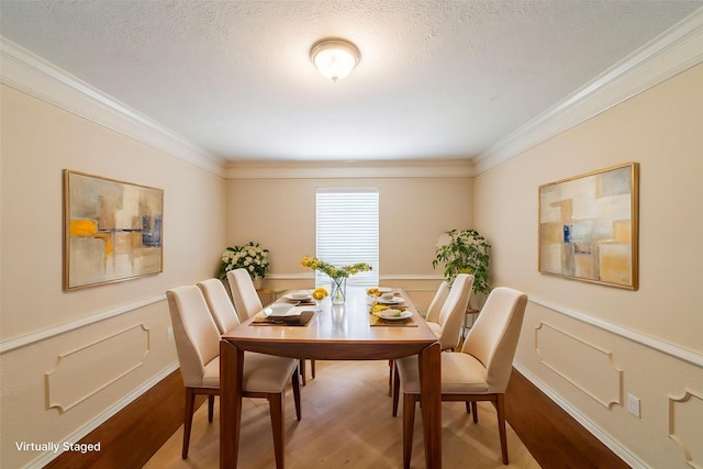 6914 Coral Ridge Rd, Houston, TX 77069 - dining space featuring crown molding, wood finished floors, a wainscoted wall, and a textured ceiling