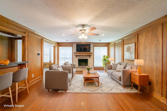 6914 Coral Ridge Rd, Houston, TX 77069 - living area featuring wood finished floors, crown molding, a ceiling fan, a fireplace, and a textured ceiling
