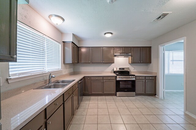 3614 Cheaney Dr, Houston, TX 77066 - kitchen with appliances with stainless steel finishes, a sink, under cabinet range hood, light countertops, and a textured ceiling