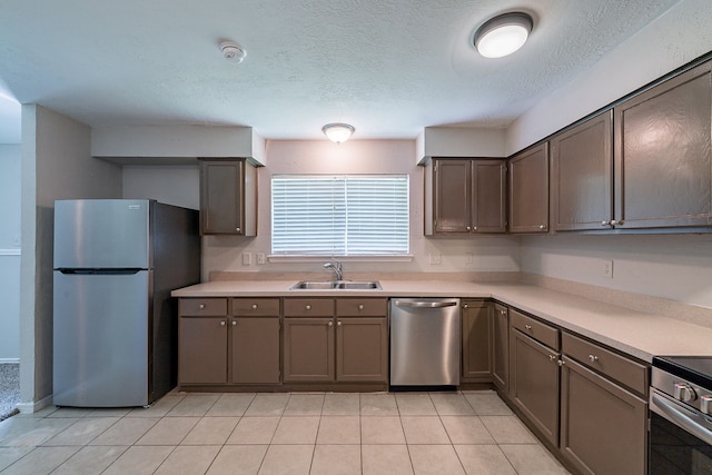 3614 Cheaney Dr, Houston, TX 77066 - kitchen with stainless steel appliances, a sink, light countertops, light tile patterned floors, and a textured ceiling