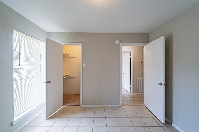 3614 Cheaney Dr, Houston, TX 77066 - unfurnished bedroom with baseboards, a walk in closet, light tile patterned floors, and a closet