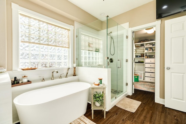 350 Pecan Estates Rd, Angleton, TX 77515 - bathroom with a walk in closet, a shower stall, wood finished floors, and a freestanding tub