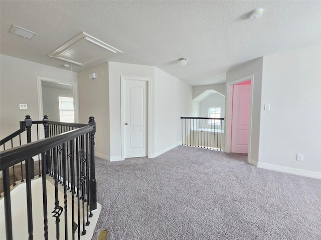 3559 Britton Burrow Way, Richmond, TX 77406 - hall with attic access, an upstairs landing, a textured ceiling, carpet, and healthy amount of natural light