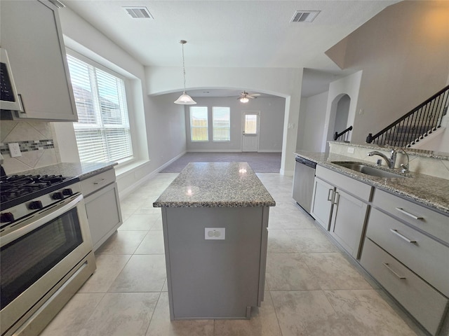 3559 Britton Burrow Way, Richmond, TX 77406 - kitchen featuring stainless steel appliances, a sink, a ceiling fan, light stone counters, and tasteful backsplash