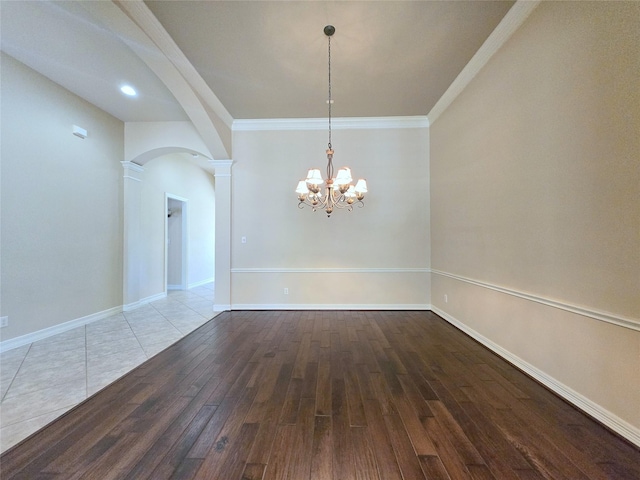 12515 Stoney Creek Dr, Pearland, TX 77584 - spare room featuring arched walkways, ornate columns, wood finished floors, a chandelier, and crown molding