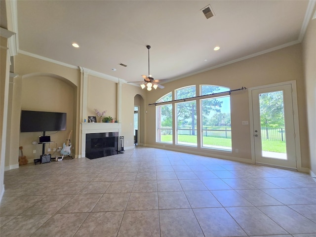 12515 Stoney Creek Dr, Pearland, TX 77584 - unfurnished living room featuring arched walkways, crown molding, light tile patterned flooring, a fireplace, and ceiling fan