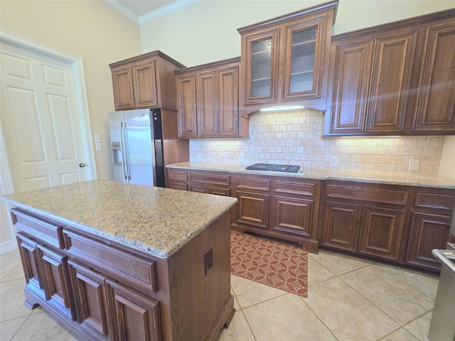 12515 Stoney Creek Dr, Pearland, TX 77584 - kitchen with stainless steel appliances, ornamental molding, light tile patterned flooring, backsplash, and light stone countertops
