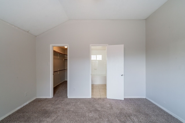 6635 Rusty Ridge Ln, Katy, TX 77449 - unfurnished bedroom with a spacious closet, carpet flooring, lofted ceiling, a closet, and baseboards