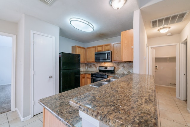 6635 Rusty Ridge Ln, Katy, TX 77449 - kitchen featuring appliances with stainless steel finishes, light tile patterned floors, decorative backsplash, and a peninsula