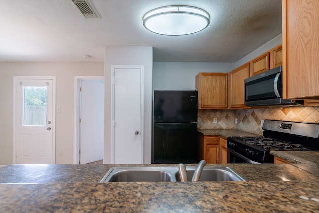 6635 Rusty Ridge Ln, Katy, TX 77449 - kitchen with appliances with stainless steel finishes, a sink, dark countertops, and backsplash
