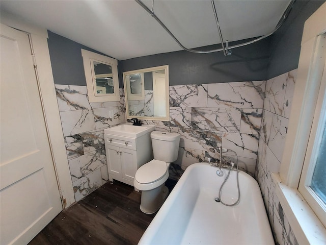 2906 Sledge St, Waller, TX 77484 - full bath with tile walls, wood finished floors, a tub, vanity, and toilet