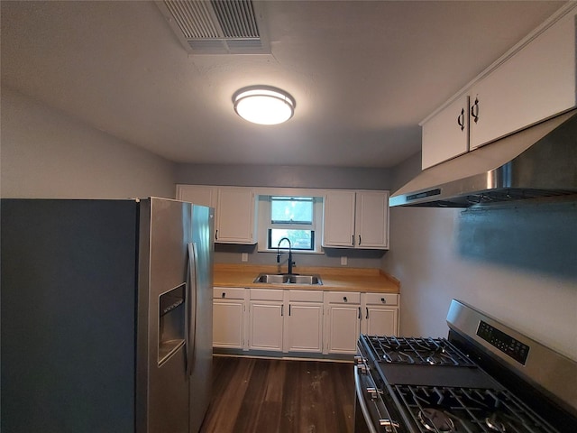 2906 Sledge St, Waller, TX 77484 - kitchen with stainless steel appliances, a sink, under cabinet range hood, white cabinetry, and dark wood-type flooring