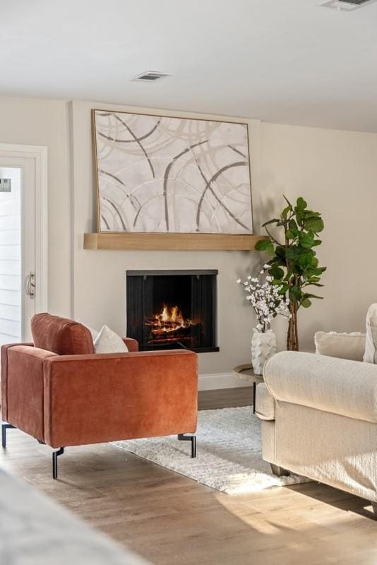 2906 Riata Ln, Houston, TX 77043 - living area with wood finished floors, a lit fireplace, and baseboards